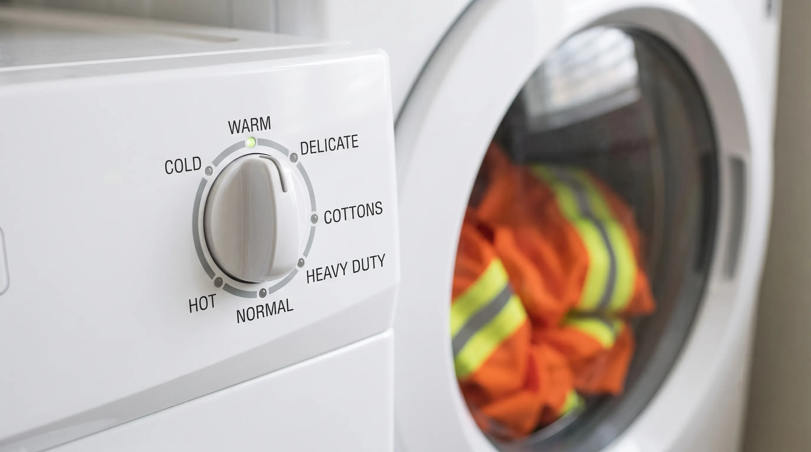 Washing machine control dial set to cold water and delicate cycle for washing hi-vis safety workwear